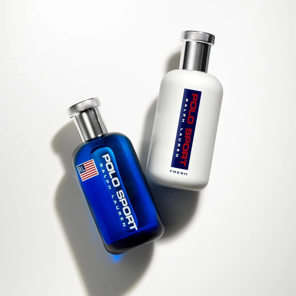 Two Polo Sport Ralph Lauren bottles, one blue and one white, on a light gray background.